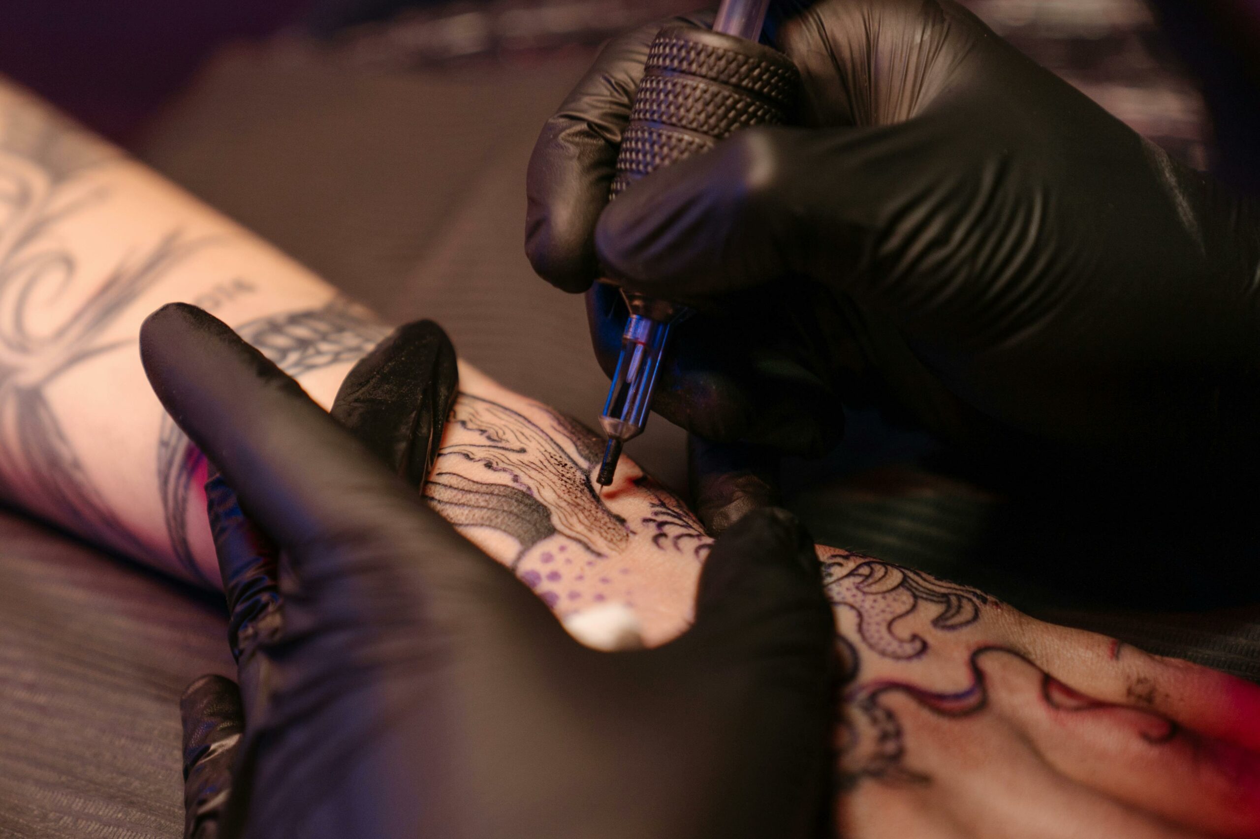 About Close-up of a tattoo artist applying ink on a client